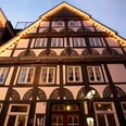 Ratskeller Fachwerkhaus in traditionellem Stil, mit beleuchtetem Giebel und dekorativen Fassadenmalereien.