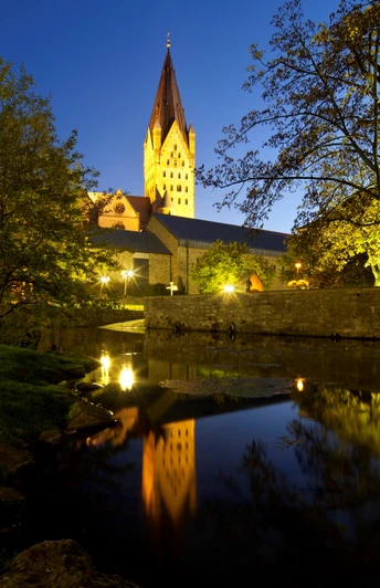 Abendlicher Blick auf den angestrahlten Dom, Kaiserpfalz und Dielenpader, gespiegelt im ruhigen Wasser.