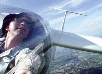 Segelflieger über Oerlinghausen Person in einem Segelflugzeug, fotografiert aus der Pilotenkabine, überblickt Felder und Landschaften.