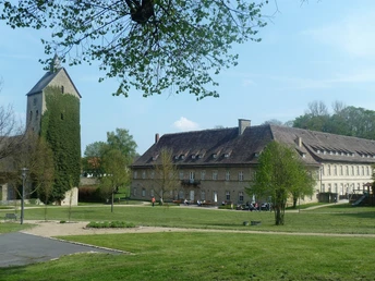 Kirche und Schloss Gehrden Historische Kirche mit Turm neben einem großen, festungsartigen Schlossgebäude in grüner Umgebung.