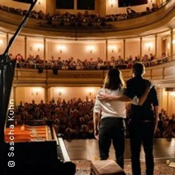 Zwei Musiker stehen auf der Bühne vor Publikum in der Christuskirche Köln