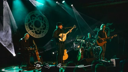 ERIC FISH & FRIENDS live Vier Musiker spielen bei einem Live-Konzert auf einer beleuchteten Bühne vor Publikum.