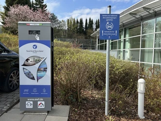 E-Ladesäule am Sauerland Stern Hotel mit Hinweisschild und parkendem Auto