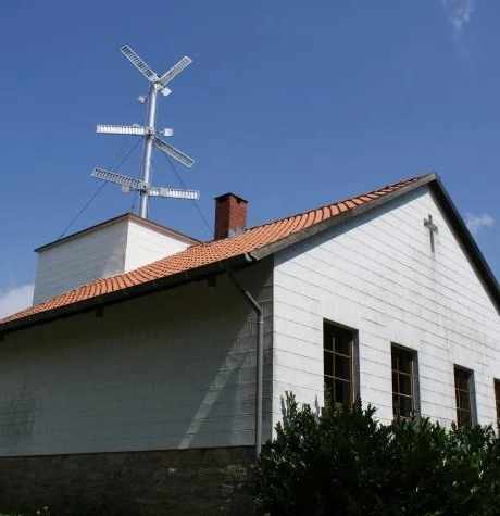 Oeynhausen, Telegrafenstation Weißes Gebäude mit kleinem Kirchturm und Telegrafenstation auf dem Dach unter strahlend blauem Himmel.