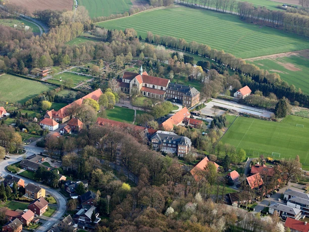 Klosteranlage Marienfeld aus der Vogelperspektive Luftaufnahme eines dörflichen Geländes mit Kirche, umliegendem Grün und mehreren Gebäuden.