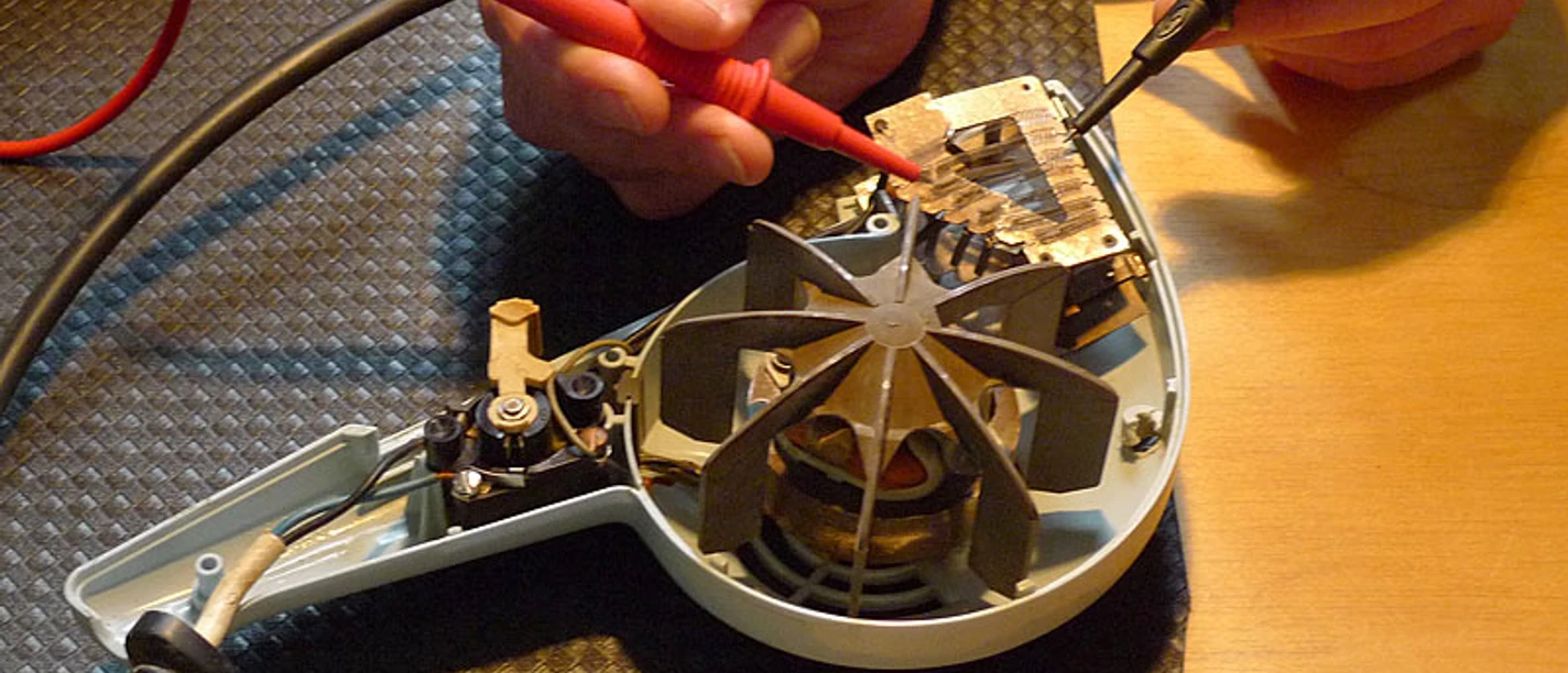 Ein geöffnetes elektrisches Gerät (Fön) wird repariert