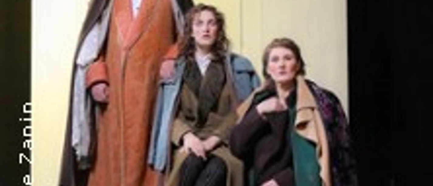 Drei Darstellende in historischen Kostümen auf einer Theaterbühne.