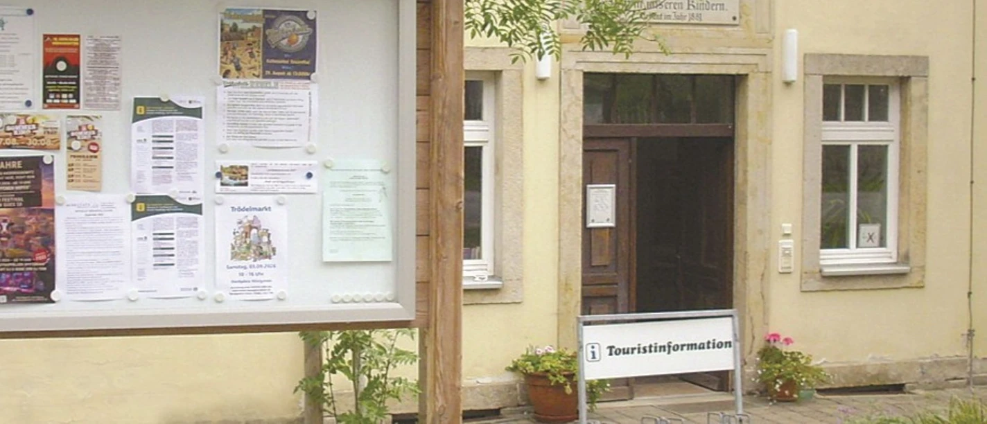 Hauswand mit Tür, im Vordergrund Infotafel; Ort Rosenthal-Bielatal