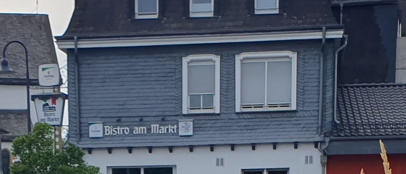 Bistro am Markt Freienohl Da Stipo.jpg Fassade des Bistro am Markt in Freienohl mit Schieferfront, Eingang und Sitzplätzen davor