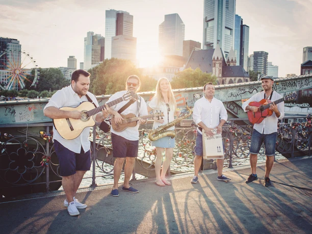 Rumbacoustic_Live-Musik Live-Musik auf einer Brücke vor der Frankfurter Skyline im Sonnenuntergang.