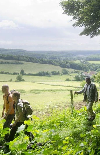 Wanderer Eine Gruppe von fünf Wanderern genießt einen malerischen Ausblick auf eine grüne Hügellandschaft.