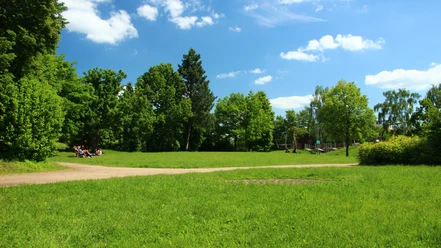 RheinMain Dietzenbach - Hessentagspark Weite grüne Wiese im Hessentagspark mit Bäumen, Spazierweg und blauem Himmel