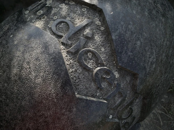 Detail einer verwitterten Skulptur am Geschichtspfad Dietzenbach mit erhabener Jahreszahl