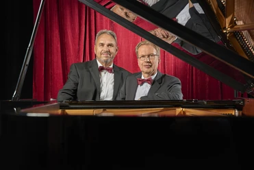 Duo Kurzweil 2 Männer stehen am Flügel.