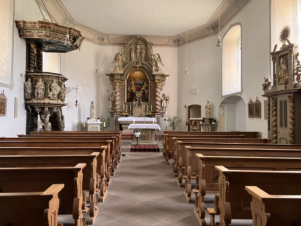 Blick in die Katholische Kirche in Drenke mit Sitzbänken, Altar, Hochaltar und Kanzel im Barockstil.