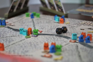 Brettspiel mit bunten Tierfiguren, Würfeln und Spielchips