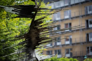 Metallskulptur „Die Genesende“ von Norbert Kricke vor unscharfem Gebäudeblick