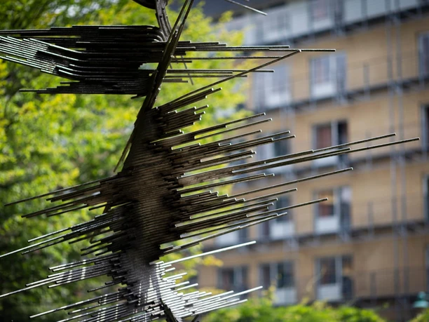 Metallskulptur „Die Genesende“ von Norbert Kricke vor unscharfem Gebäudeblick