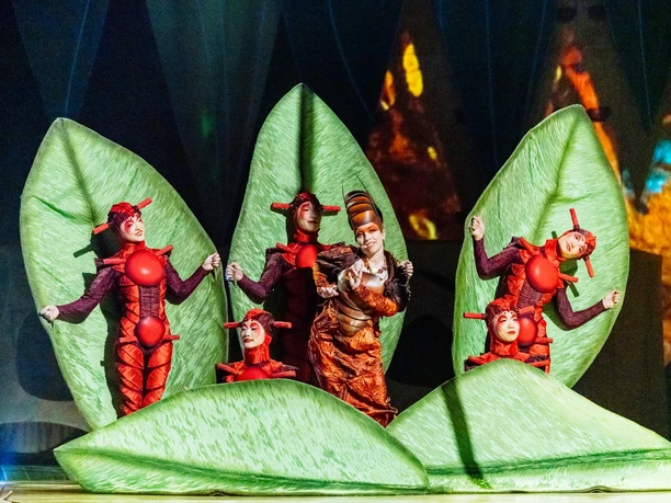 Cirque du Soleil - OVO Performers in insect costumes among large green leaves at Cirque du Soleil OVO