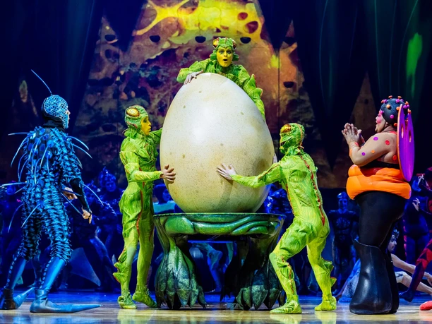 Cirque du Soleil - OVO Performers in colorful insect costumes surround a large egg on the OVO stage