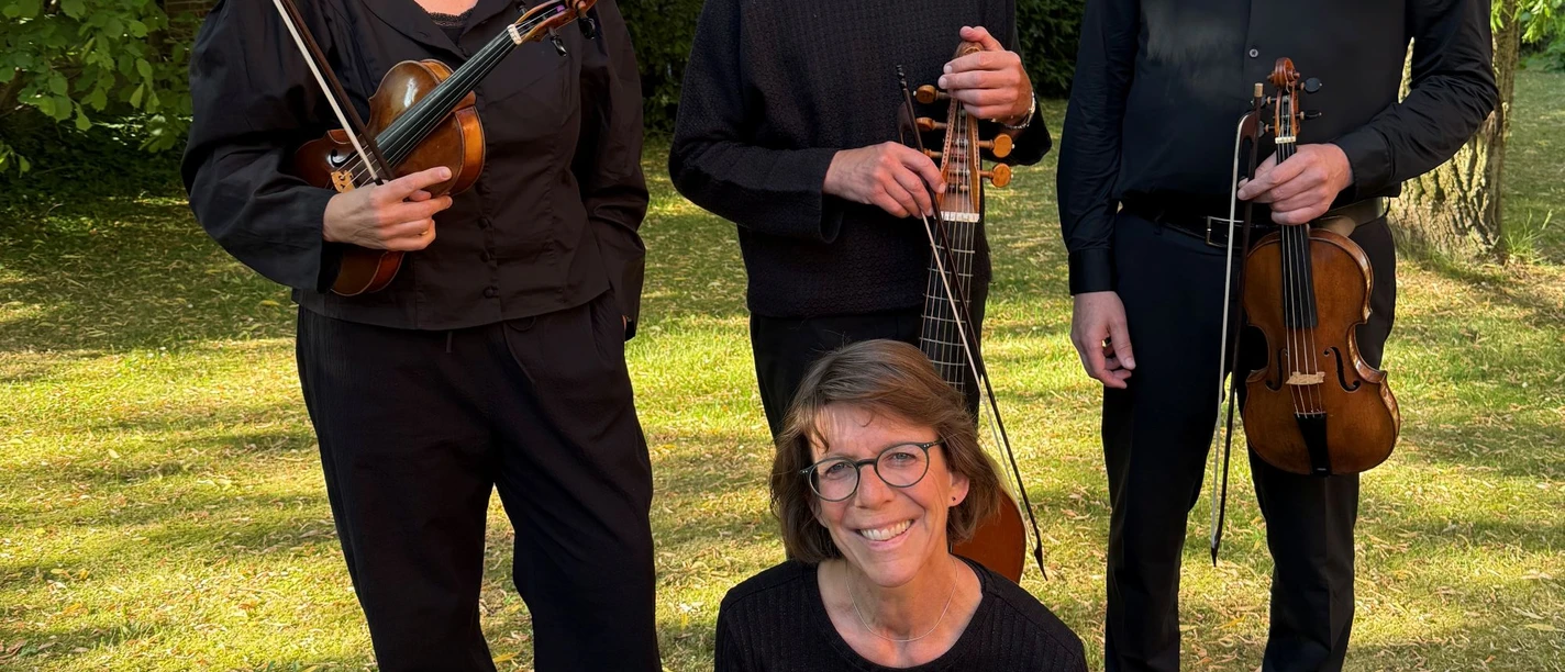 Vier Mitglieder des Ensembles La Bergamasca mit Streichinstrumenten unter Bäumen.