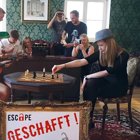 Dans une salle d'énigmes d'Escape Leipzig, un groupe résout des énigmes à l'aide d'un échiquier, d'un violon et de caméras.