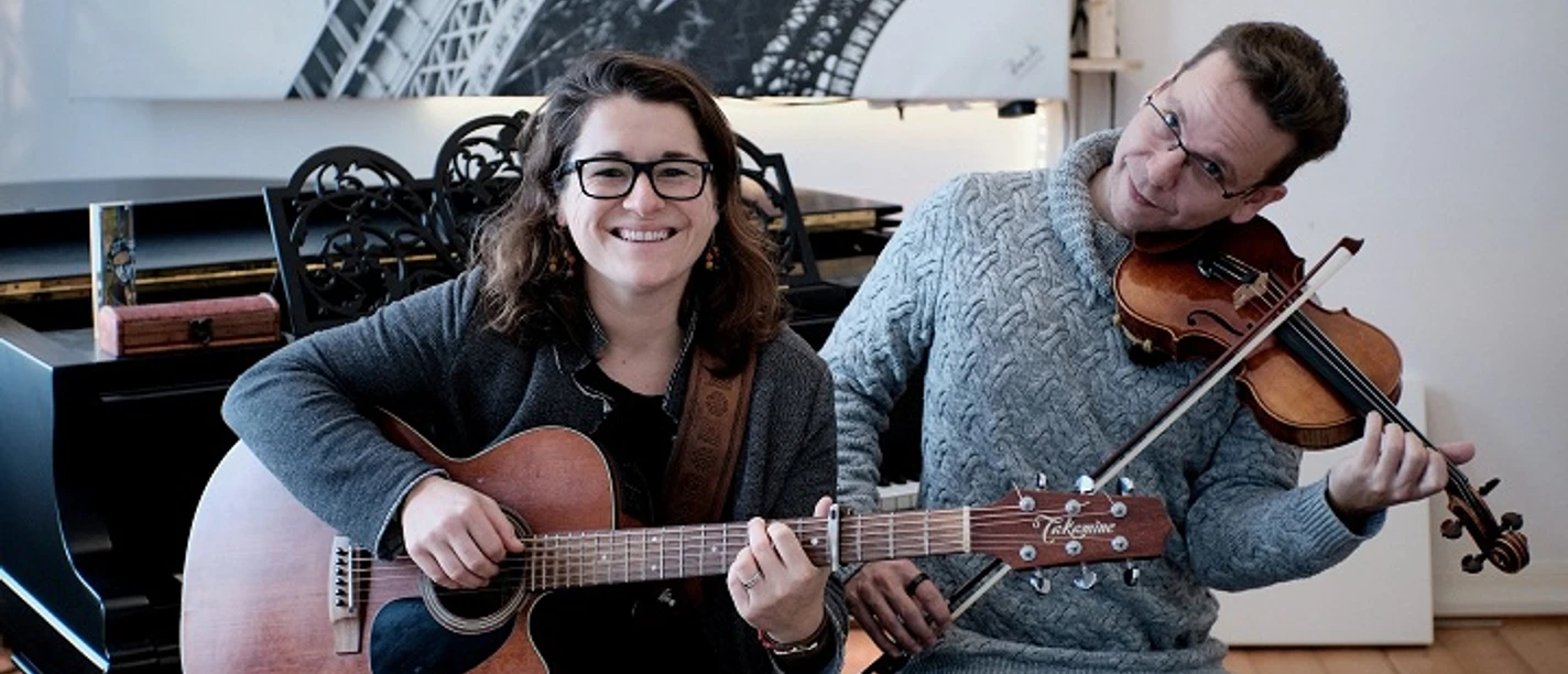 Frau an Gitarre und Mann mit Geige spielen zusammen