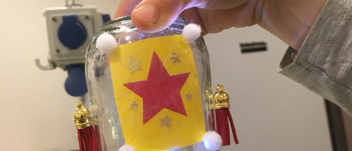 eine Hand hält ein selbstgebautes Kipplicht aus Glas
