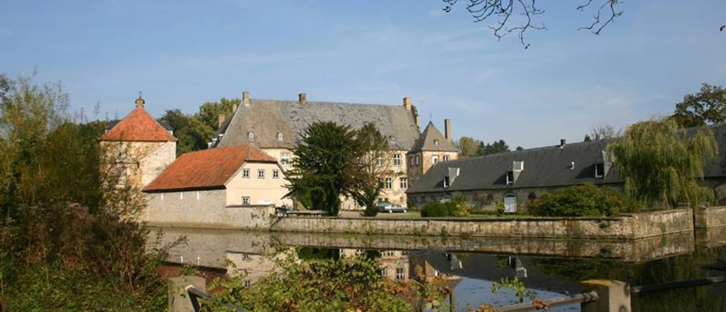 Halle Westfalen, Wasserschloss Tatenhausen Wasserschloss Tatenhausen in Halle Westfalen, von Bäumen umgeben, spiegelt sich im Wassergraben.