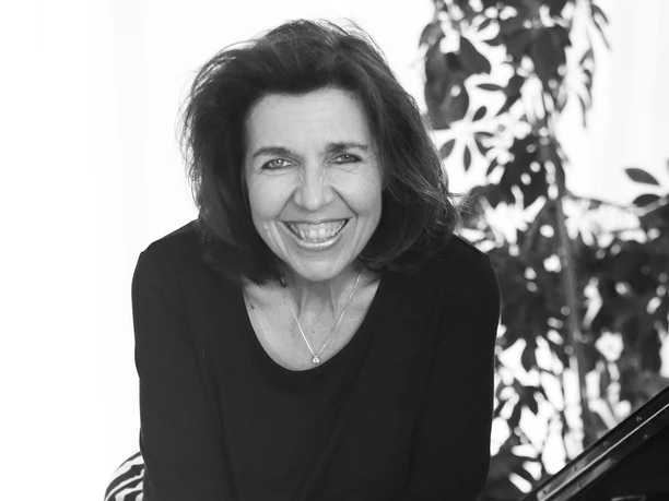 Susi-Weiss-Piano-Kaffeehausmusik-sw.jpg Lächelnde Pianistin am Flügel in Schwarzweiß