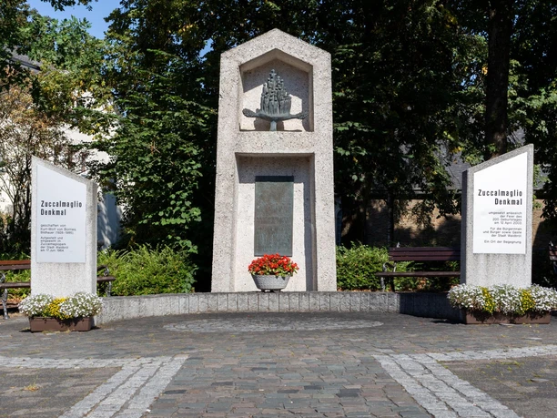 Zuccalmaglio-Denkmal in Waldbröl mit Steintafeln, Blumen und Bänken unter Bäumen