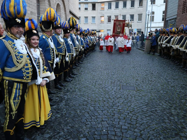 Procession honoring the city's patron saints, with blue-and-yellow guards, in front of St. Gereon's Church in Cologne