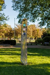 Basalt-Lava-Säule von Berthold Welter mit farbigen Glaseinsätzen im grünen Stadtpark