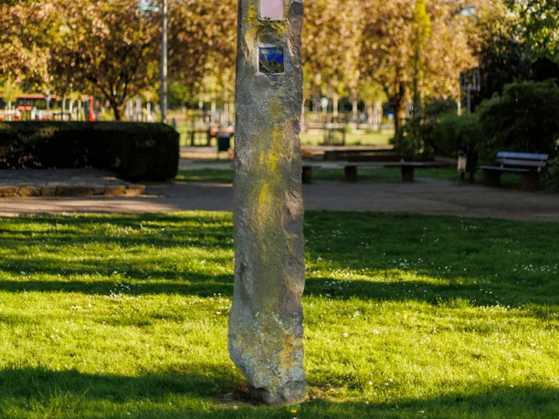 Basalt-Lava-Säule von Berthold Welter mit farbigen Glaseinsätzen im grünen Stadtpark