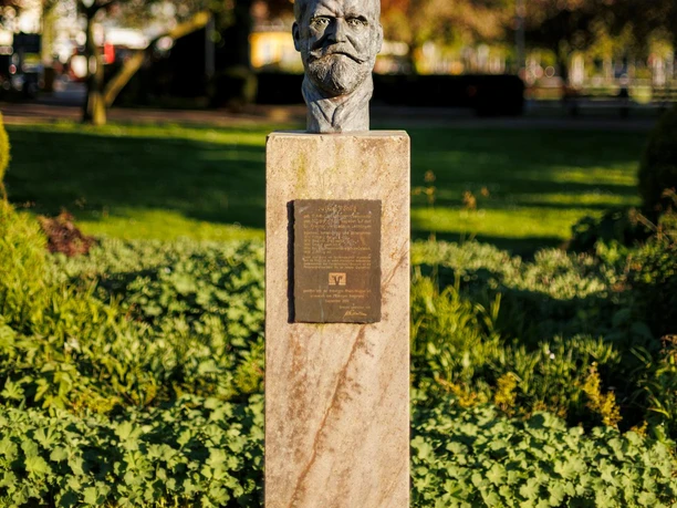 Julius-Pohlig-Büste auf Steinsockel vor grüner Parkanlage