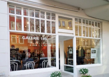 BIK Galerie 149, Außenansicht Fassade der Galerie 149 mit großen Fenstern, Glastür und Spiegelungen der Straße.
