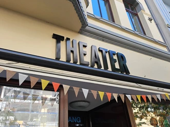 Schwarzer Theater-Schriftzug am Piccolo Haventheater mit bunter Wimpelkette.