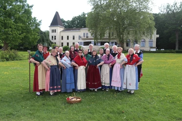 Trachten-Gruppe auf einer Wiese vor dem Alten Kurhaus in Bad Zwischenahn.