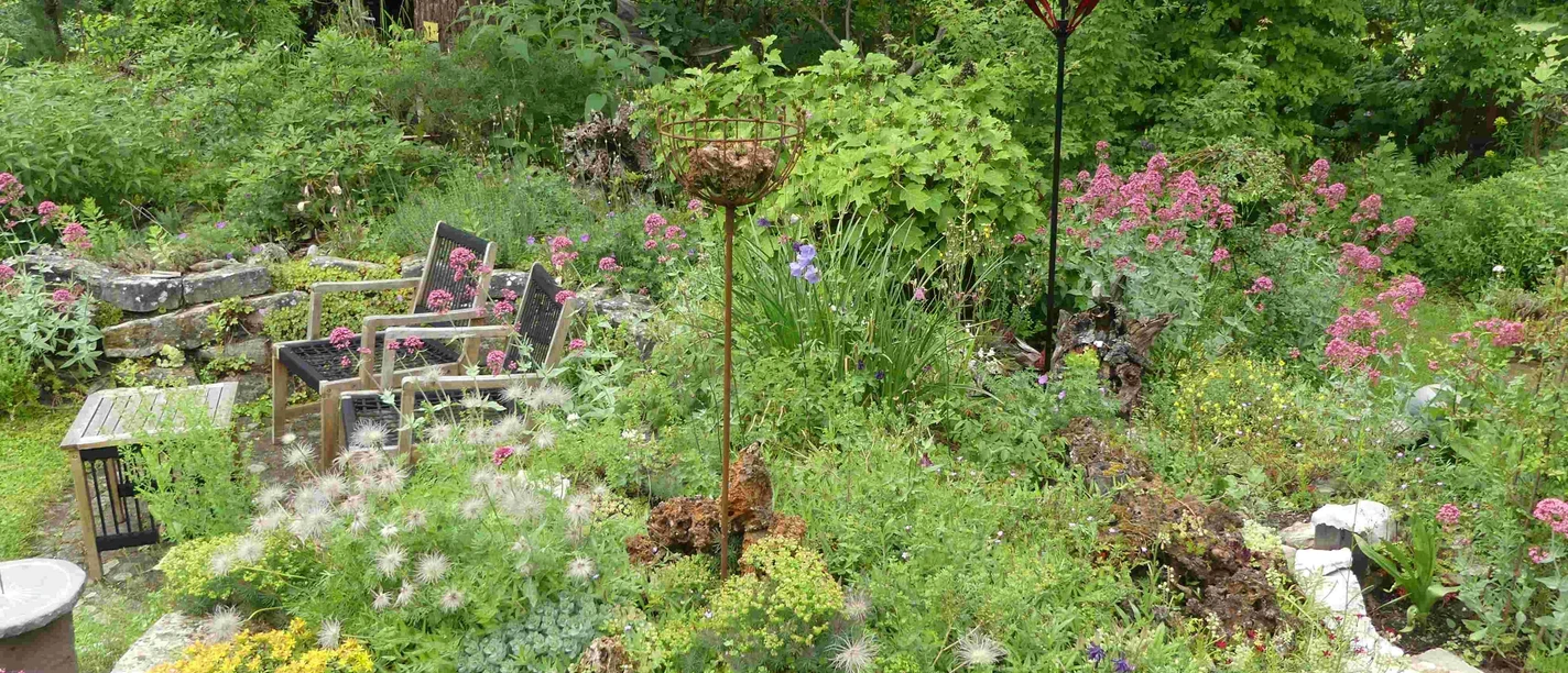 Gärten Ein schöner Garten mit bunten Blumen und üppigem Grün. Sitzgelegenheiten laden zum Entspannen ein.