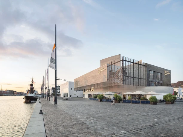 Deutsches Auswandererhaus am Hafen in Bremerhaven mit Museumsvorplatz und Schiff.