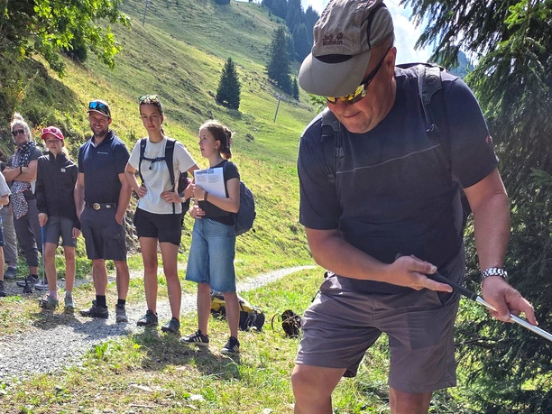 Ein Mann spielt den Ball ab einen selbstgebauten Punkt während die Gruppe zuschaut