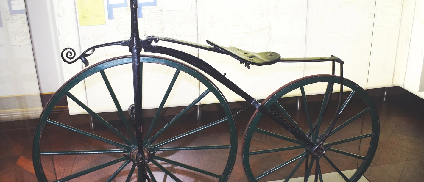 Historisches Fahrrad mit großem Vorderrad in einer Ausstellung der Evenburg.