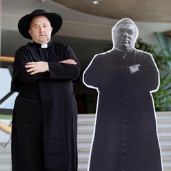 Sebastian Kneipp Ein Priester steht neben einer Lebensgroßen Pappfigur, die ihn in traditioneller Kleidung darstellt. Beide haben die Arme über der Brust verschränkt.