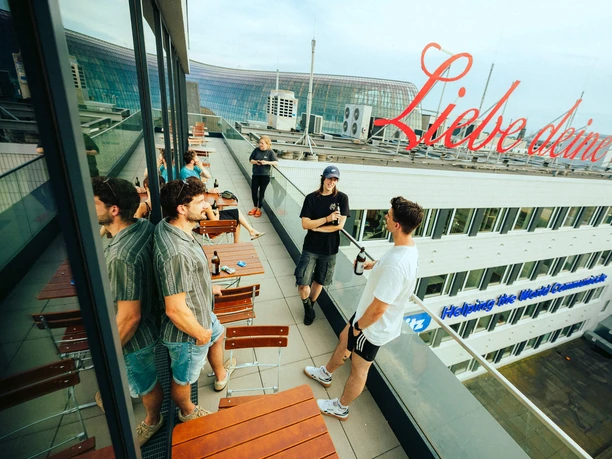 ElementBoulders LoveYourCity The rooftop terrace at ELEMENT Boulders Cologne, featuring guests and red lettering that reads “Love Your City”