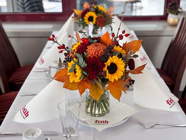 A festively set brunch table with an autumnal bouquet and white FRÜH napkins