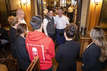 A group on a brewery tour at FRÜH am Dom with two employees in the dining area