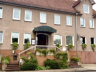 Eingangsbereich zum Gasthaus mit Treppen und schöner Bepflanzung.