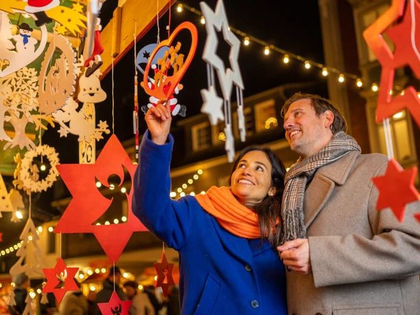 Besuch auf dem Blotshcenmarkt in Mettmann Ein Paar betrachtet lächelnd den hölzernen Weihnachtsschmuck auf dem Blotschenmarkt.