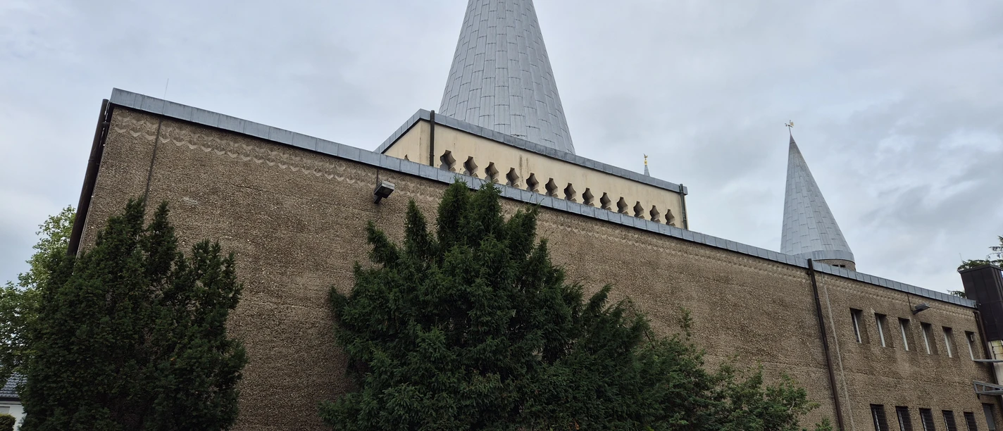 Herz-Jesu Kirche Herz-Jesu-Kirche in Schildgen mit zwei Spitztürmen vor bewölktem Himmel
