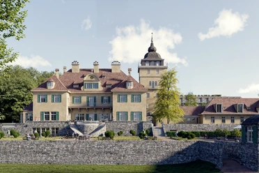 Schloss Lerbach Schloss Lerbach mit Turm, Terrasse und Parkmauern vor hellem Himmel